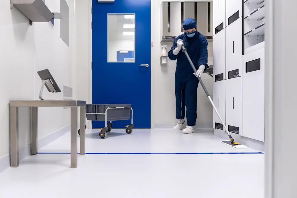 Cleaner vacuuming the floor of a newly completed facility